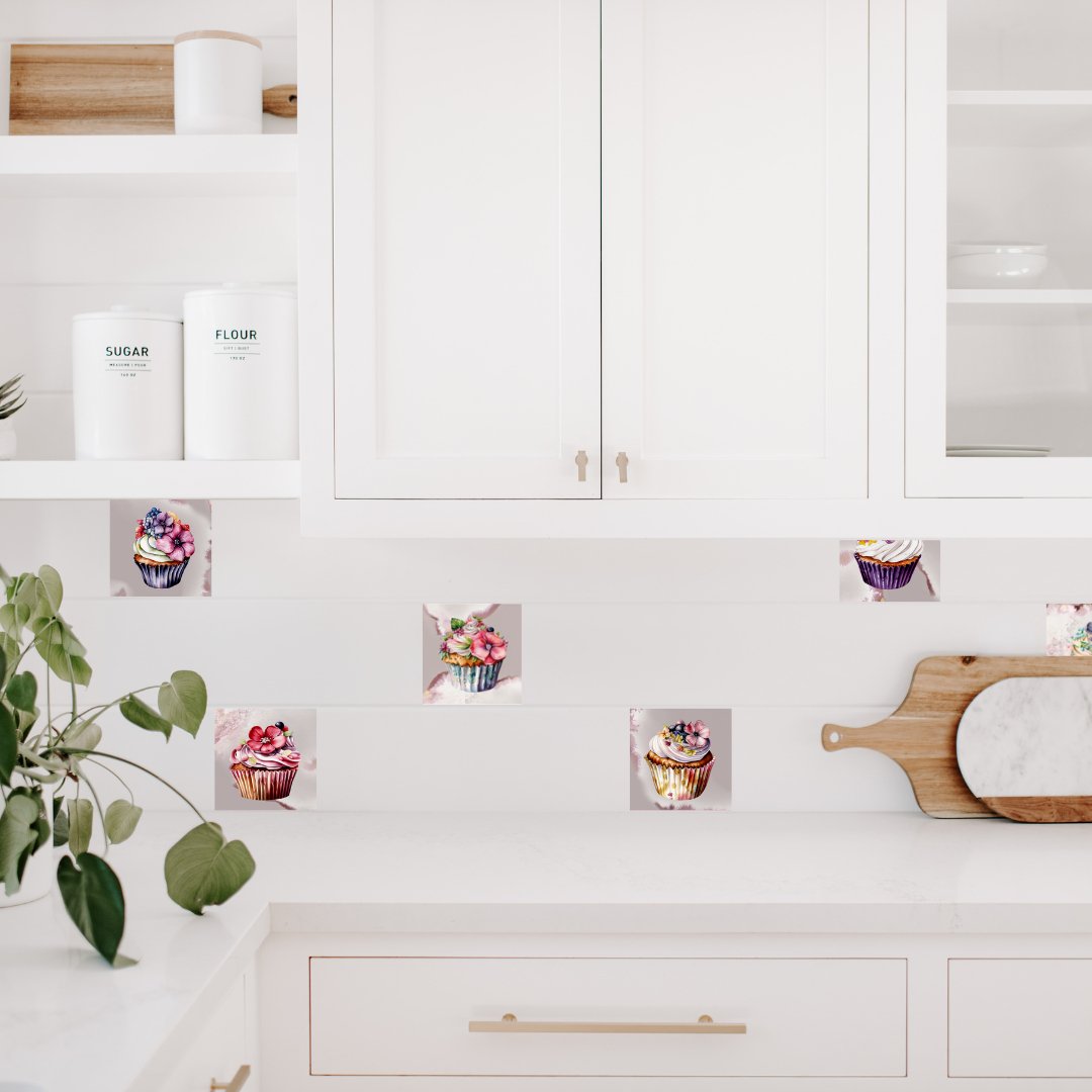 Køkken med smukke cupcake flisestikcers på nogle af fliserne på bagvækken. Fliesklistermærkerne har mange farve, hvoilket giver meget liv til det hvide køkken.
