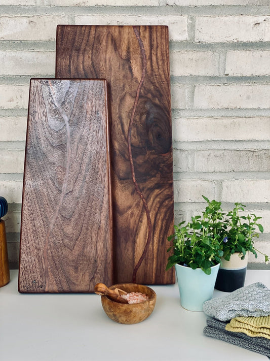 Smukt og tidsløst skærebræt i valnød med en åre af kobber epoxy, som understreger åren i træets struktur.