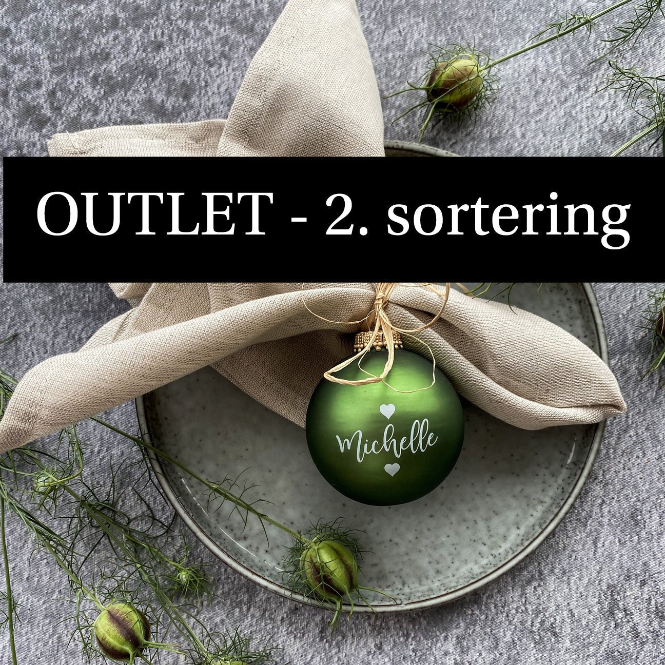 OUTLET julekugle. Mosgrøn julekugle på tallerken. Julekuglen er med navn og små hjerter. Julekugle er brugt som bordkort.